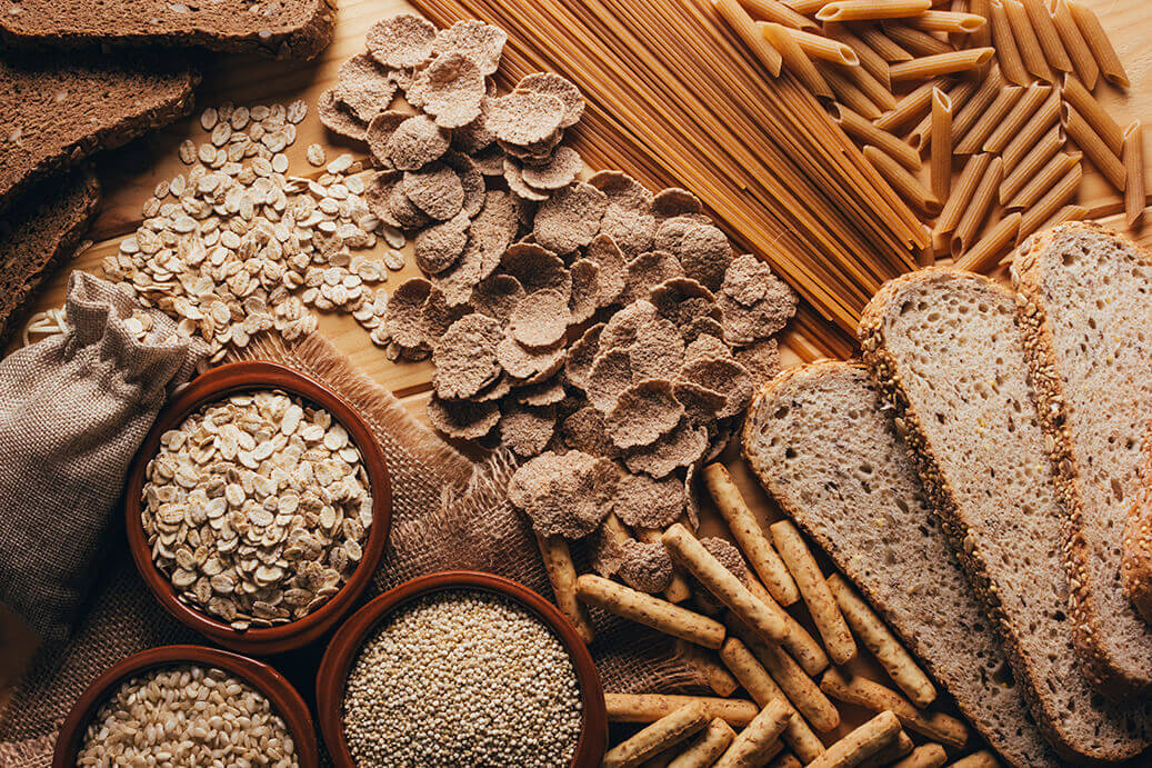 Different carbs like bread and grains placed on a table