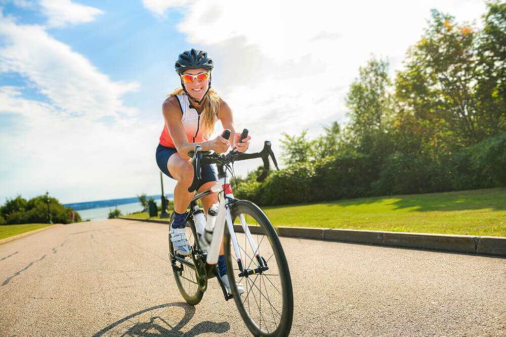 A cyclist smiling on a bike and enjoying health benefits of cycling